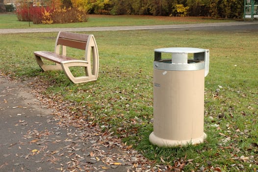 Dust bin bench and autumn leaves somewhere in park