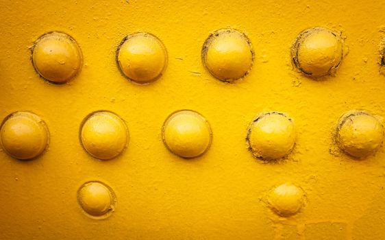 yellow metal background with rivets