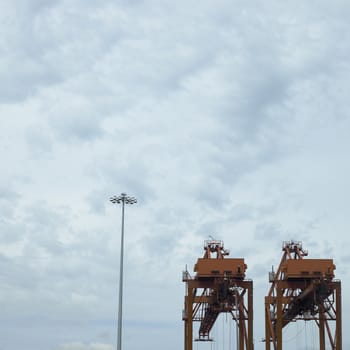 large orange port cranes and cloudy sky