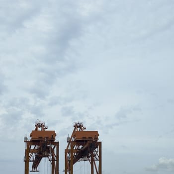 large orange port cranes and cloudy sky