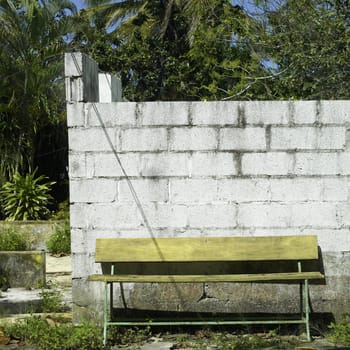 yellow bench in fron of abandonned structure