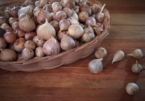 fresh single  garlic head in basket on wood textured single garlic head good quality than other garlic kind more value for heathy medical mixed