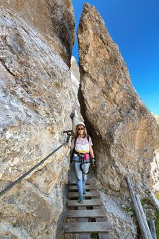 womann on equipped pathway with small bridge in Dolomites - Bepi Zac ferrata, Trentino, Italy