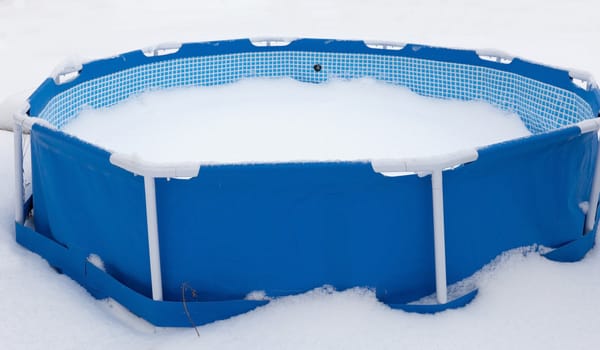 Abandoned swimming pool at winter, surrounded with snow. winter Landscape