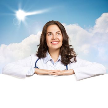 Young attractive female doctor put her hands on the blank banner, place for text