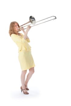 young woman in yellow playing trombone and white background
