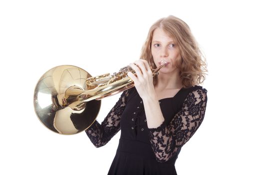 young pretty woman playing french horn against white background