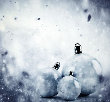 Christmas glass balls on winter background with snow storm, frost, glittering lights. Vintage texture.