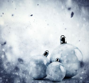 Christmas glass balls on winter background with snow storm, frost, glittering lights. Vintage texture.