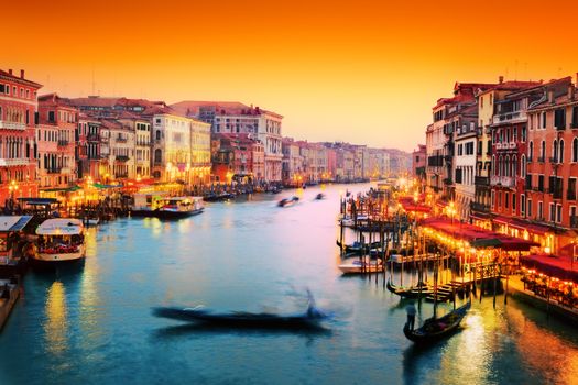 Venice, Italy. Gondola floats on Grand Canal, Italian Canal Grande at sunset. View from Rialto Bridge