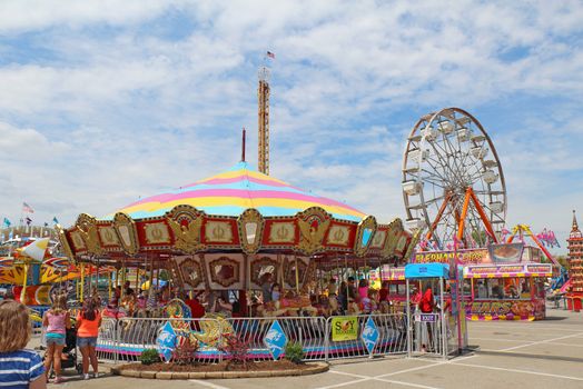 INDIANAPOLIS, INDIANA - AUGUST 12: The ferris wheel and carousel rides on the Midway at the Indiana State Fair on August 12, 2012. This very popular fair hosts more than 850,000 people every August.