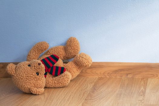 Single teddy bear on a floor in a child room