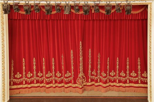 Theatrical red velvet curtain with gold pattern