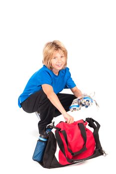 a young boy, ready for putting on his football shoes and play football