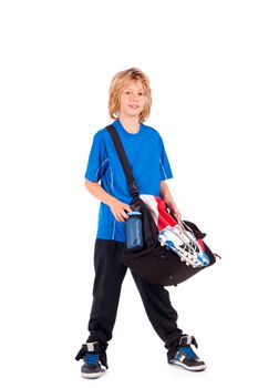 a young boy, ready for going to play football, with his sportbag and football