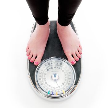 a girl on a weighing scale, on a white background