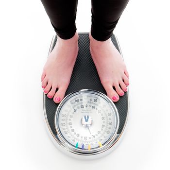 a girl on a weighing scale, on a white background