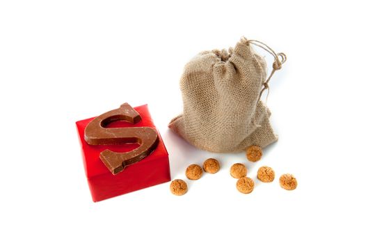 A jute bag full of pepernoten, a present and a chocolate letter, for celebrating a dutch holiday " Sinterklaas "  on the fifth of December