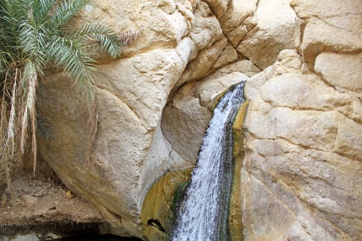 A waterfall flows from the mountain