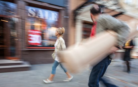 Sale. A man with a big roll and a young woman going shopping with discounts