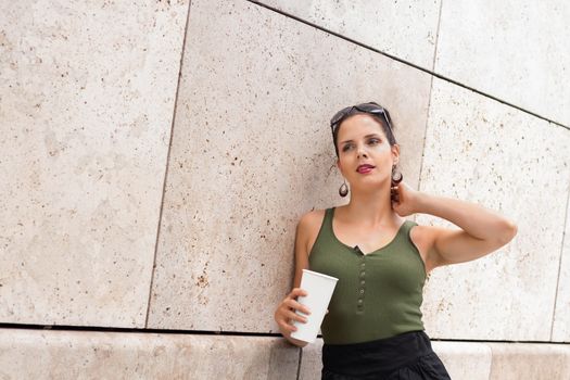 attractive young woman with coffee to go and sunglasses outdoor in summer