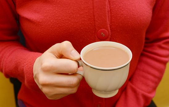 Teacup of white tea in a woman's hand