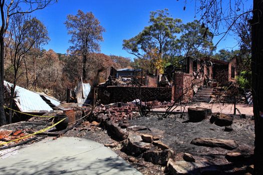 After the fire.   Bushfire destroys homes and vehicles in a random pattern while some are spared completely, others are razed to the ground.