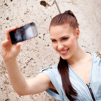 attractive young woman with smartphone camera photos outdoor in summer