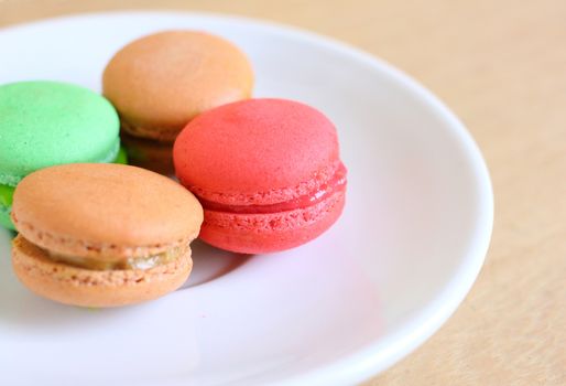 Tasty colorful macaroons on wooden background