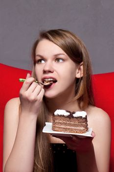 girl with pleasure eats chocolate cake