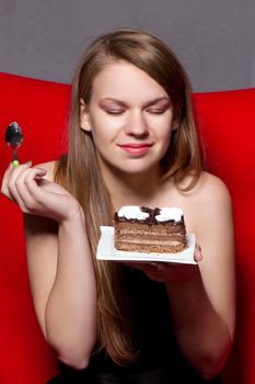 girl with pleasure eats chocolate cake