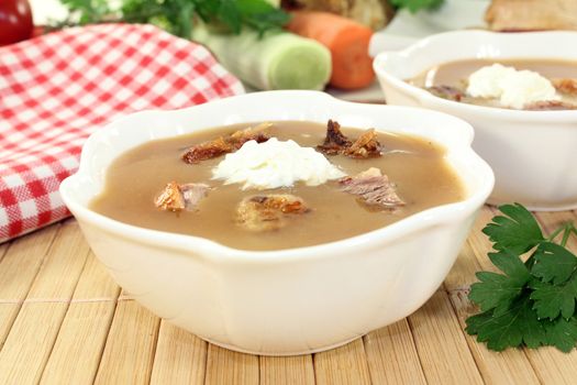 white bowls with duck soup and cream
