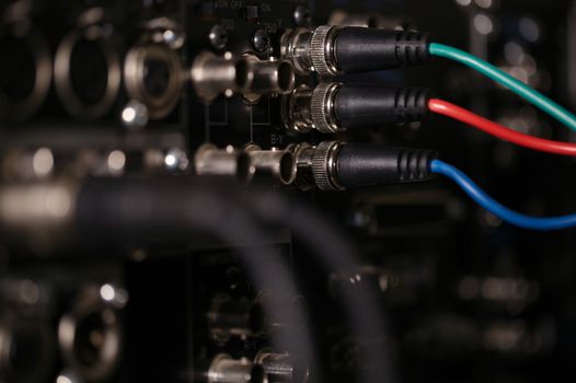 RGB video cables in the rear panel of the professional VCR. XLR audio cables in blur.