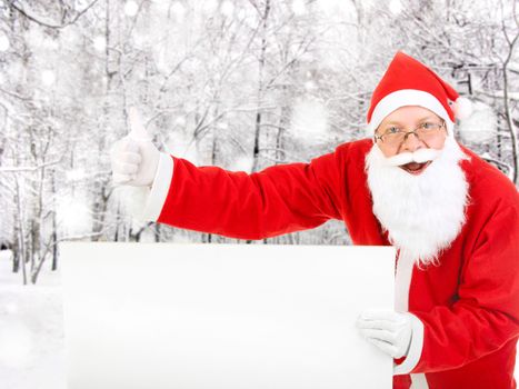 Happy Santa Claus with Empty white Board in the Winter Forest