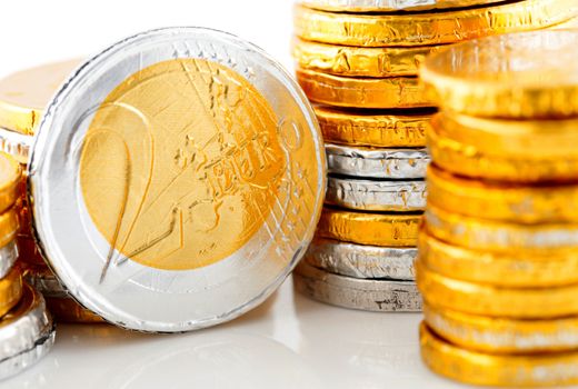pile of chocolate Euro money in closeup over white background