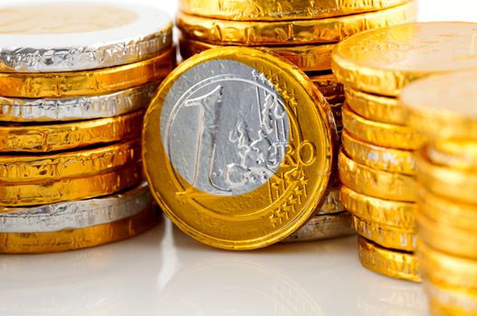 pile of chocolate Euro money in closeup over white background