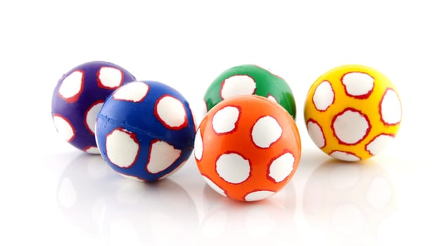 Five colorful balls in closeup over white background