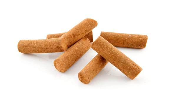 Pile of cinnamon sticks in closeup over white background