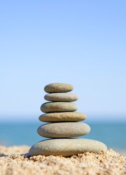 stack of zen stones near the ocean on sunny day