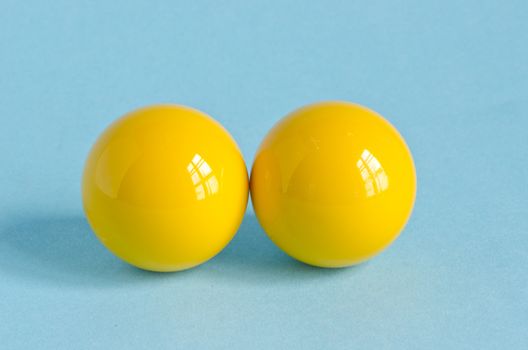 two yellow billiards ball on blue background