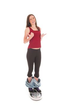 a girl on a weighing scale, celebrating her success of loosing weight