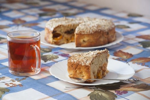 Apricot pie on plate and cup with tea. High resolution