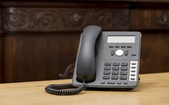 modern phone on wooden table in living room with old commode