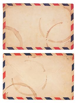 The front and back of an aging, coffee-stained airmail envelope with red and blue striped border. Isolated on white with clipping path.