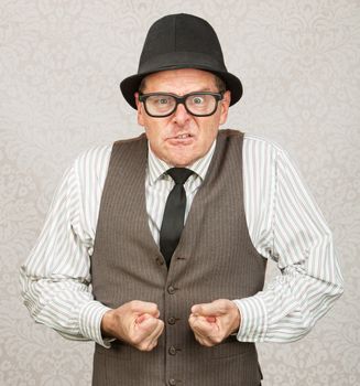 Insulted white male with eyeglasses clenching fists