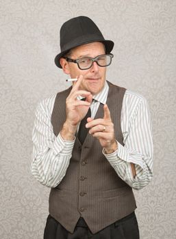 Man in hat and eyeglasses smoking with finger pointing