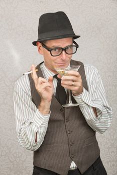 Smirking businessman with hat and eyeglasses drinking alcohol