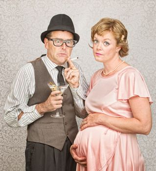 Worried man with martini and cigarette next to pregnant woman