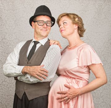 Man with folded arms and happy pregnant female