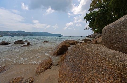 View through rocks on coastline of beach of sea,Thailand .